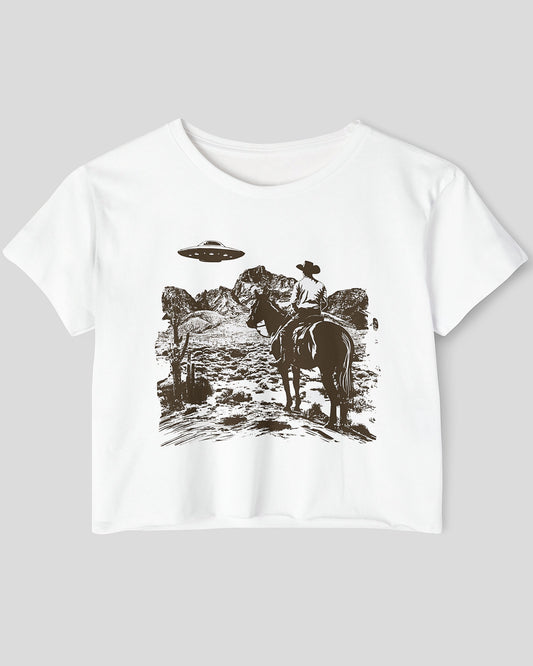 Flat-lay white crop top featuring a UFO and western desert scenery graphic.
