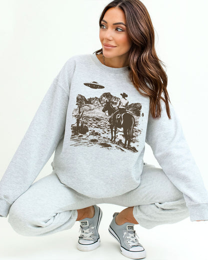Woman wearing an ash gray UFO western graphic sweatshirt.