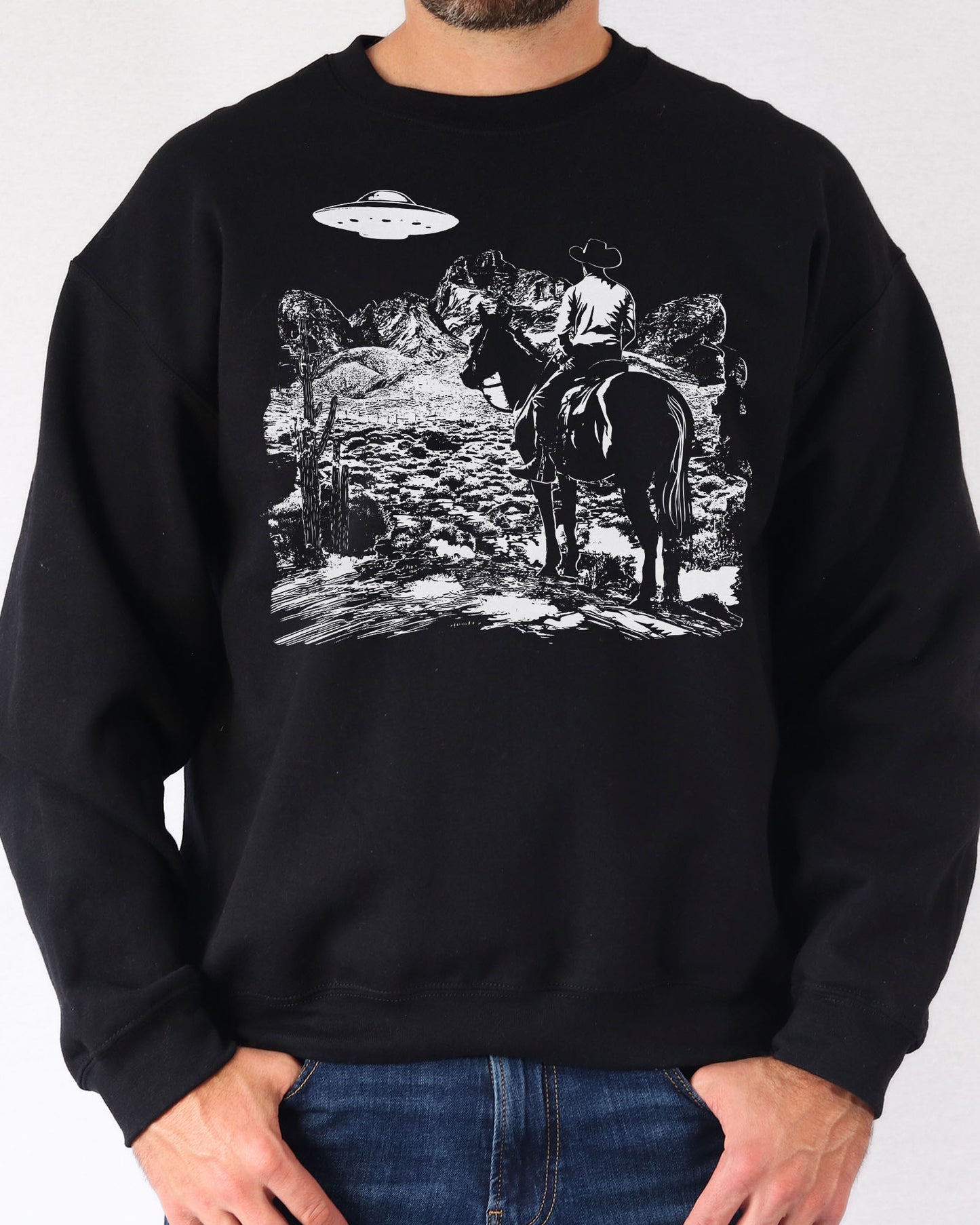 Man wearing a black UFO western graphic sweatshirt.