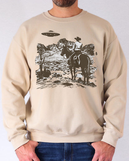Man wearing a sand beige UFO western graphic sweatshirt.