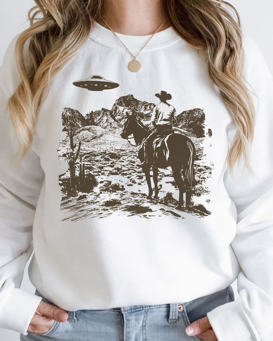 Woman wearing a white UFO western graphic sweatshirt.