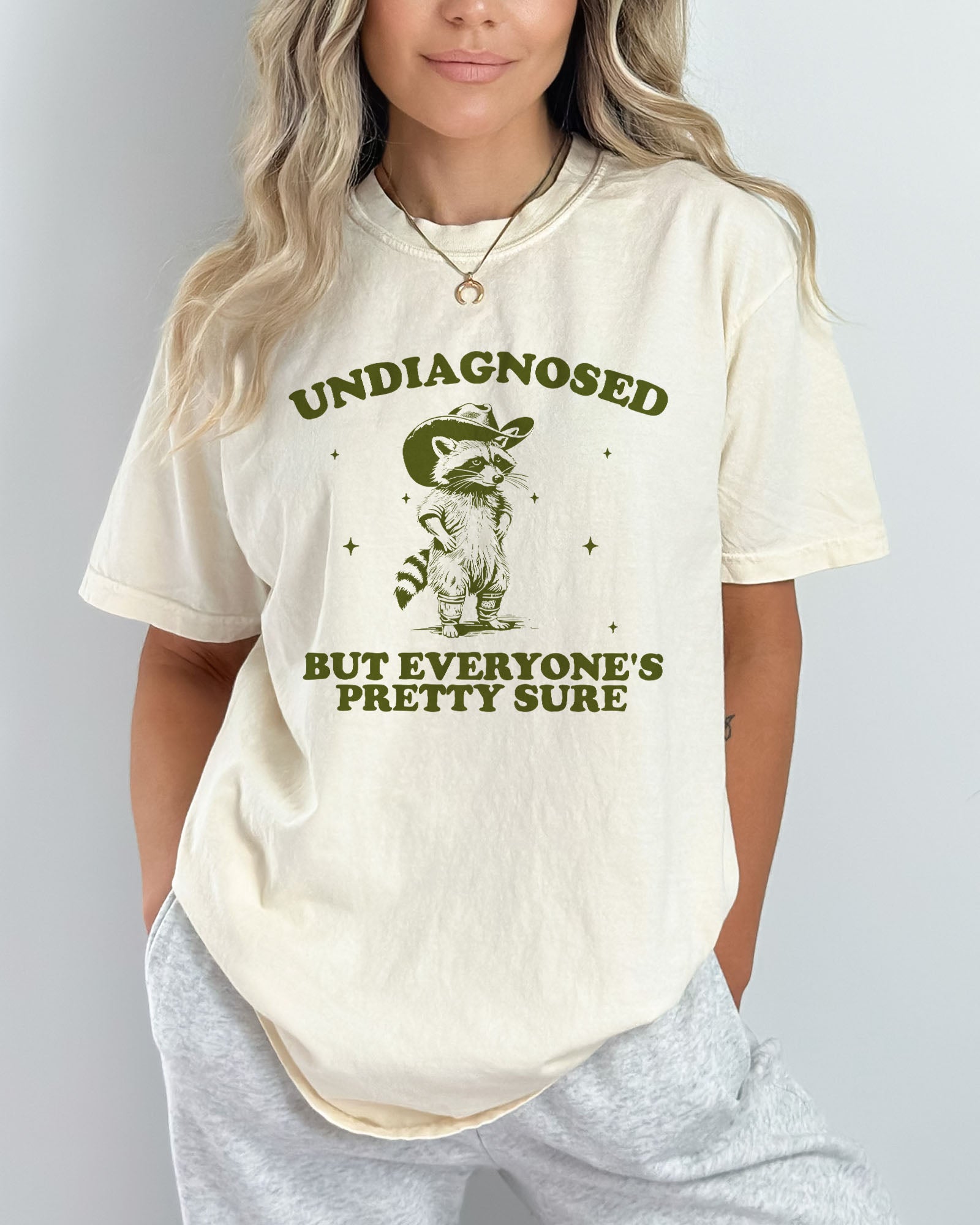 Model wearing natural color shirt with 'Undiagnosed But Everyone Is Pretty Sure' graphic design