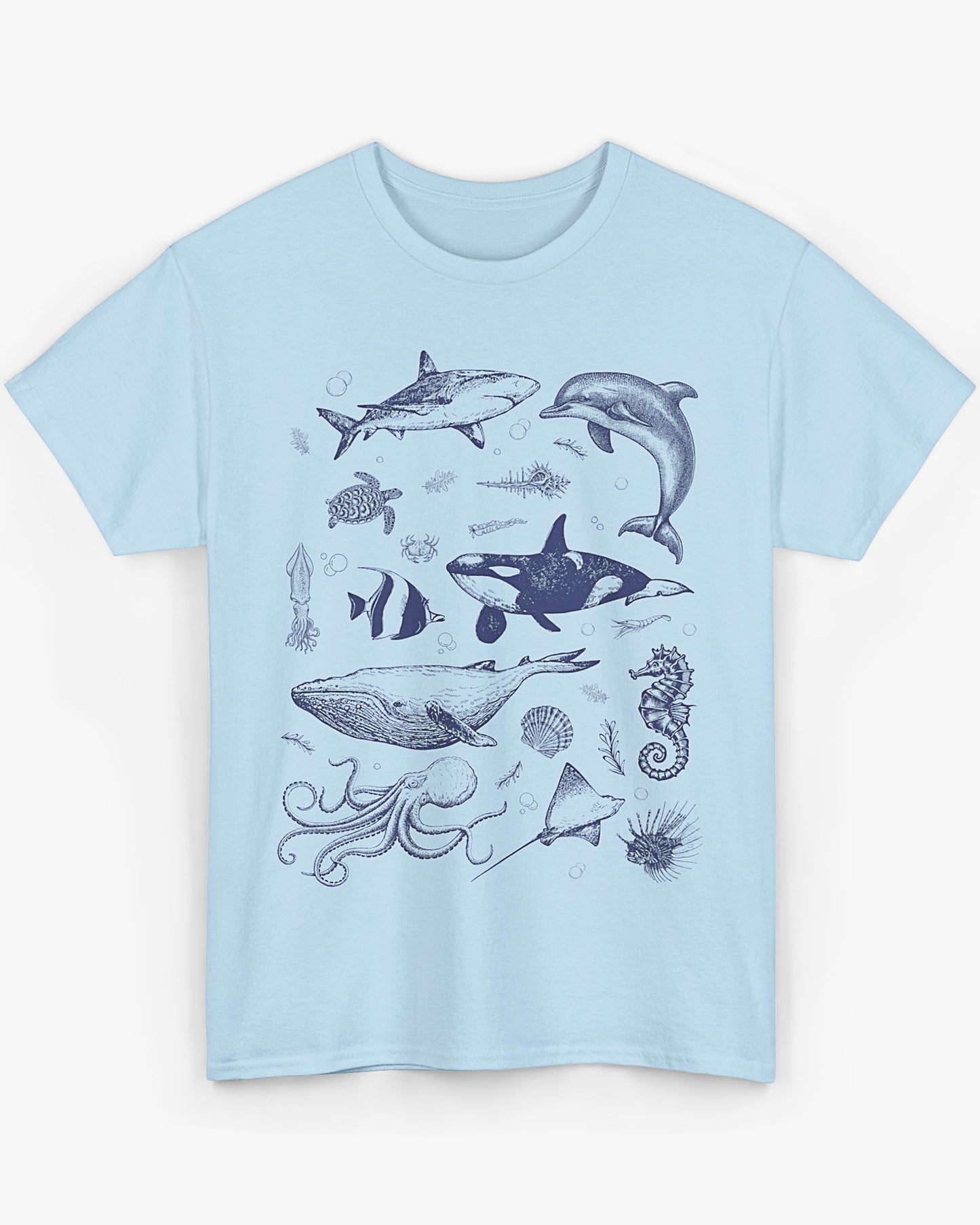 Flat laying light blue shirt featuring a vintage 90s sea creatures collage graphic with whales, dolphins, turtles, and ocean life, perfect for retro nature lovers