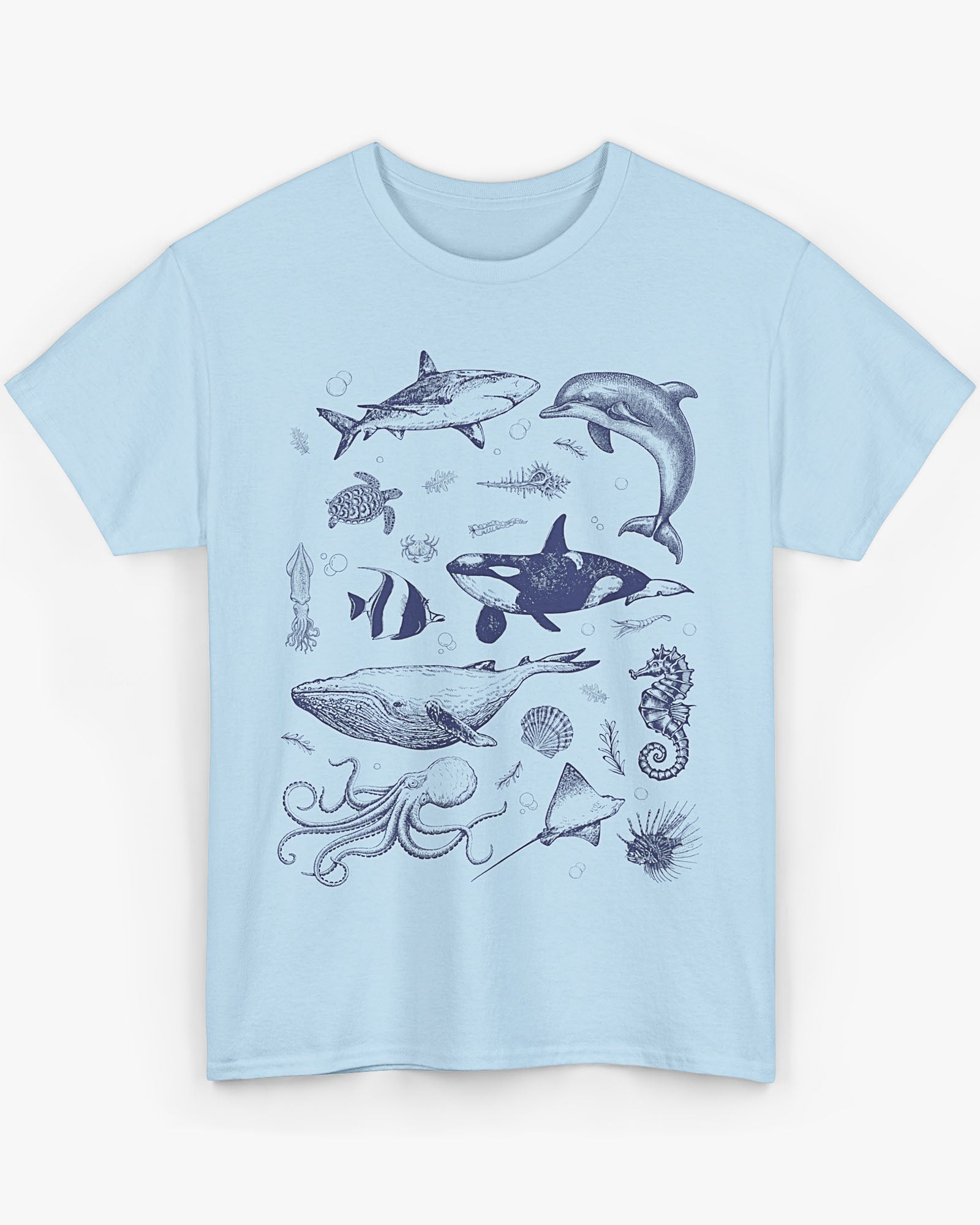 Flat laying light blue shirt featuring a vintage 90s sea creatures collage graphic with whales, dolphins, turtles, and ocean life, perfect for retro nature lovers