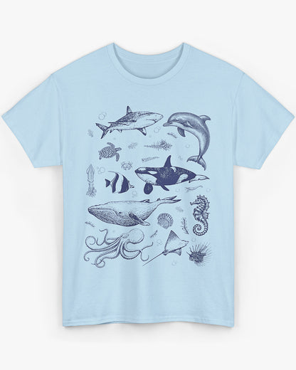Flat laying light blue shirt featuring a vintage 90s sea creatures collage graphic with whales, dolphins, turtles, and ocean life, perfect for retro nature lovers