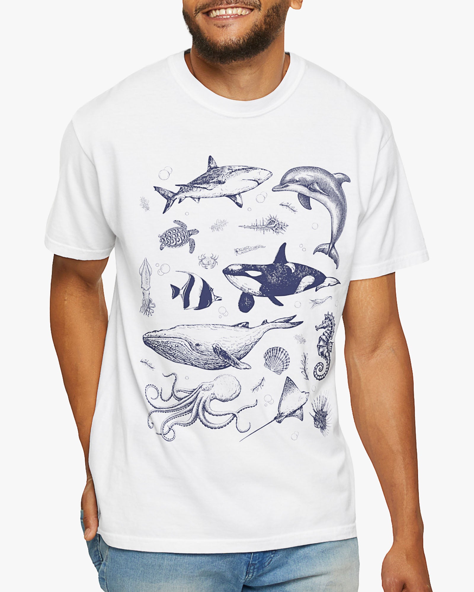 Man wearing a white shirt featuring a vintage 90s sea creatures collage graphic with whales, dolphins, turtles, and ocean life, perfect for retro nature lovers