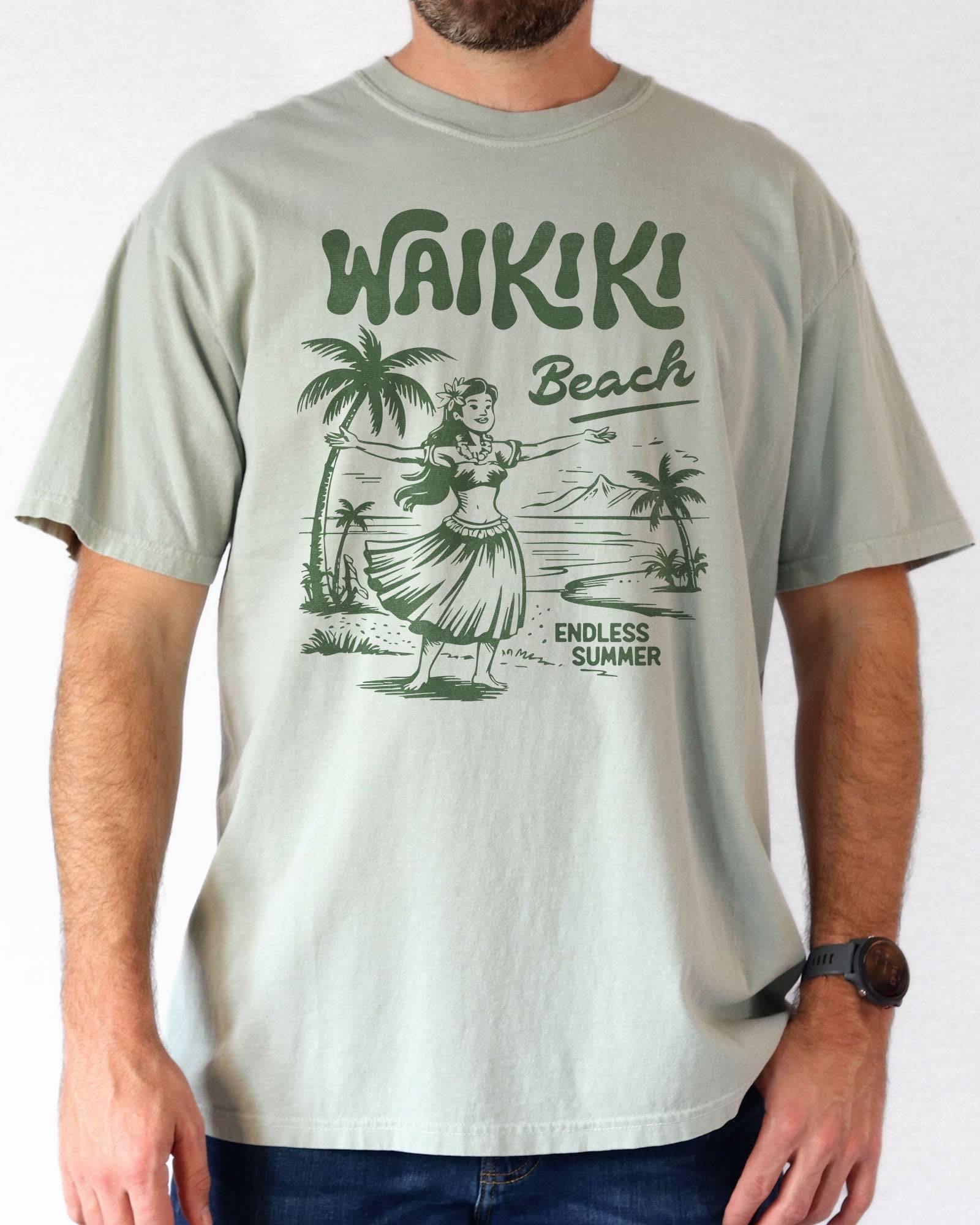 Woman wearing a bay "Waikiki Beach – Endless Summer" shirt with a retro graphic of a Hawaiian beach and a girl.