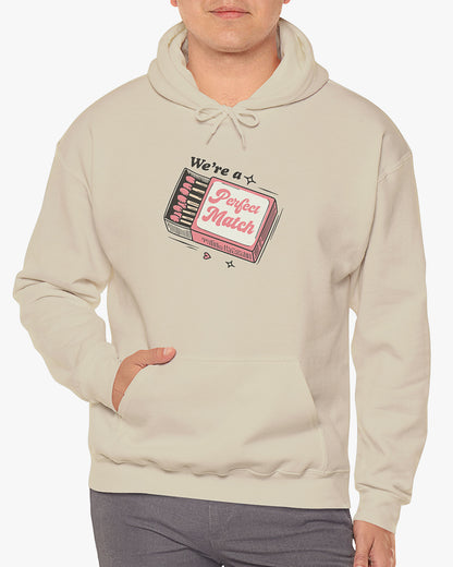 Man wearing sand beige 'We're A Match' hoodie with retro matchbox valentine's Day graphic