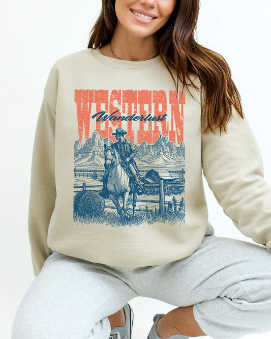 Woman wearing a sand beige sweatshirt featuring a retro graphic of a cowboy riding a horse in a Wild West scene with the quote 'Western Wanderlust'.