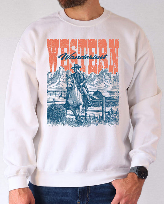 Man wearing a white sweatshirt featuring a retro graphic of a cowboy riding a horse in a Wild West scene with the quote 'Western Wanderlust'.