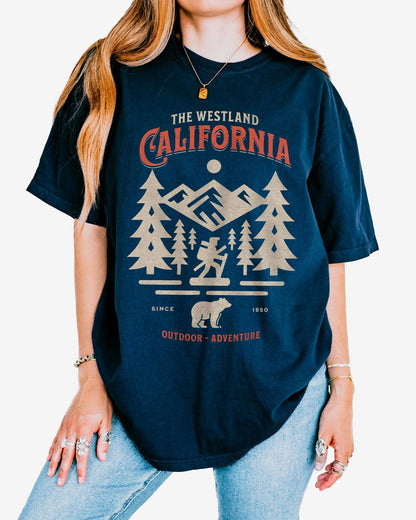 Woman wearing a true navy Westland California Outdoor Adventure shirt with a retro vector graphic of a hiker, bear, and mountains.