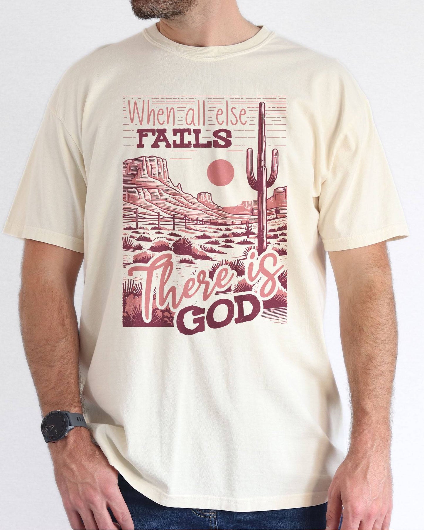Man wearing natural color shirt with 'When All Fails There Is God' graphic design
