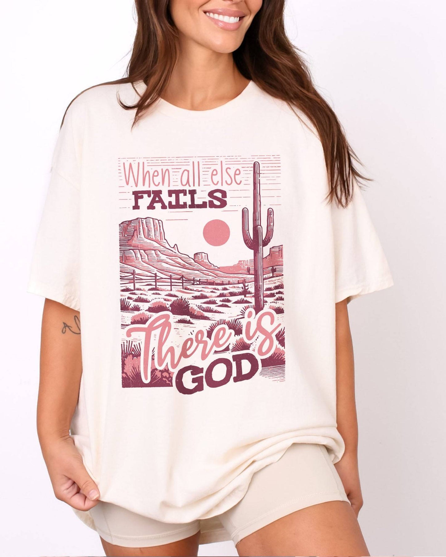 Woman wearing natural color shirt with 'When All Fails There Is God' graphic design