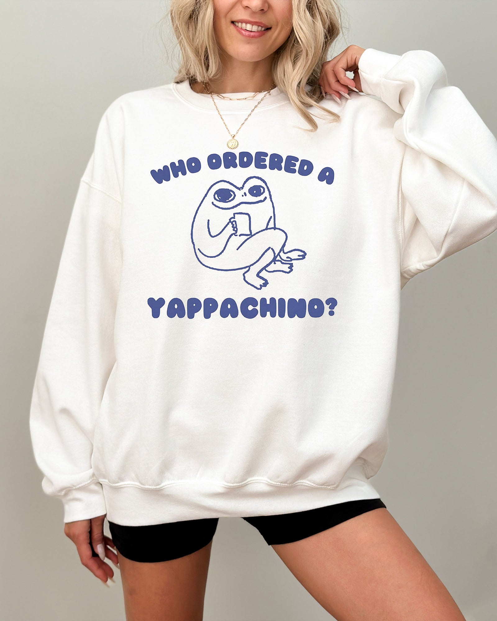 Model wearing white color sweatshirt with 'Who Ordered A Yappachino' graphic design