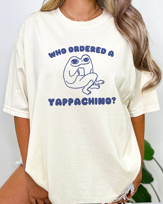 a woman wearing a who ordered a yappachino shirt in natural color