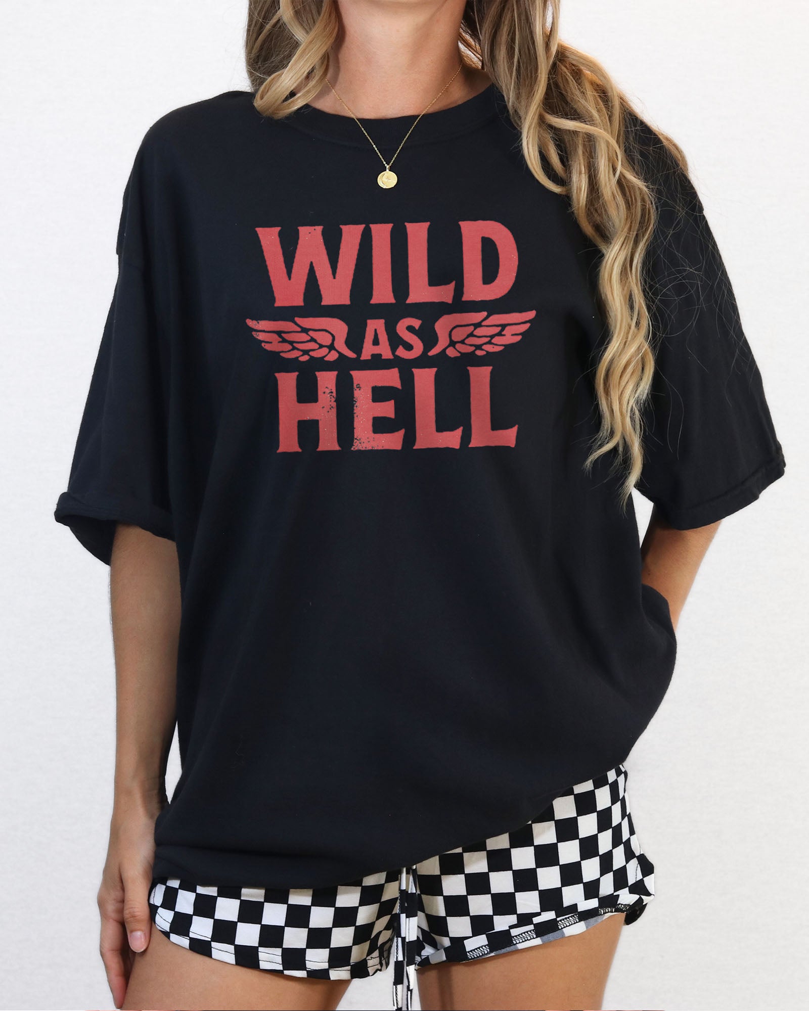 Woman wearing black "Wild As Hell" retro western graphic shirt.
