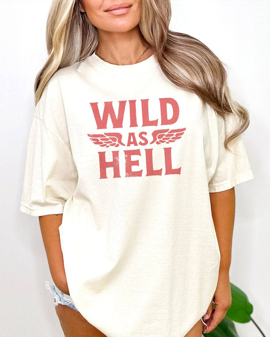 Woman wearing ivory "Wild As Hell" retro western graphic shirt.
