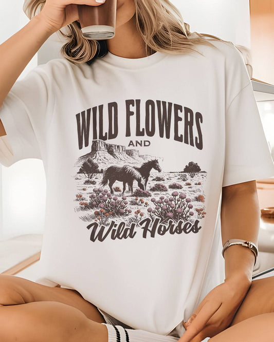Close-up of model wearing white color shirt with 'Wild Flowers And Wild Horses' graphic design
