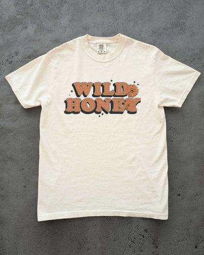 Flat Lay Wild Honey shirt laying on concrete in ivory color