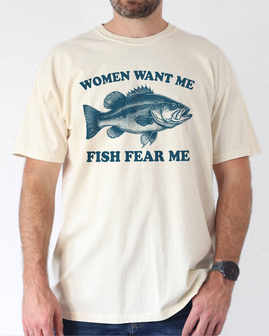 Model wearing natural color shirt with 'Women Want Me Fish Fear Me' graphic design