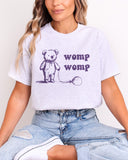 Model wearing ash color shirt with 'Womp Womp' graphic design
