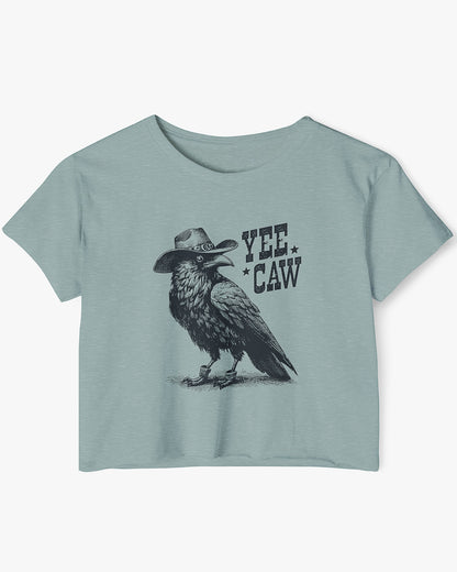 Woman wearing stonewash-green-colored 'Yee Caw' crop top featuring a funny retro cowboy crow graphic.