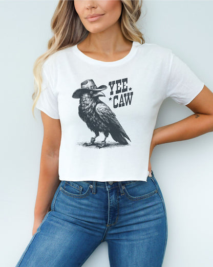 Woman wearing white-colored 'Yee Caw' crop top featuring a funny retro cowboy crow graphic.
