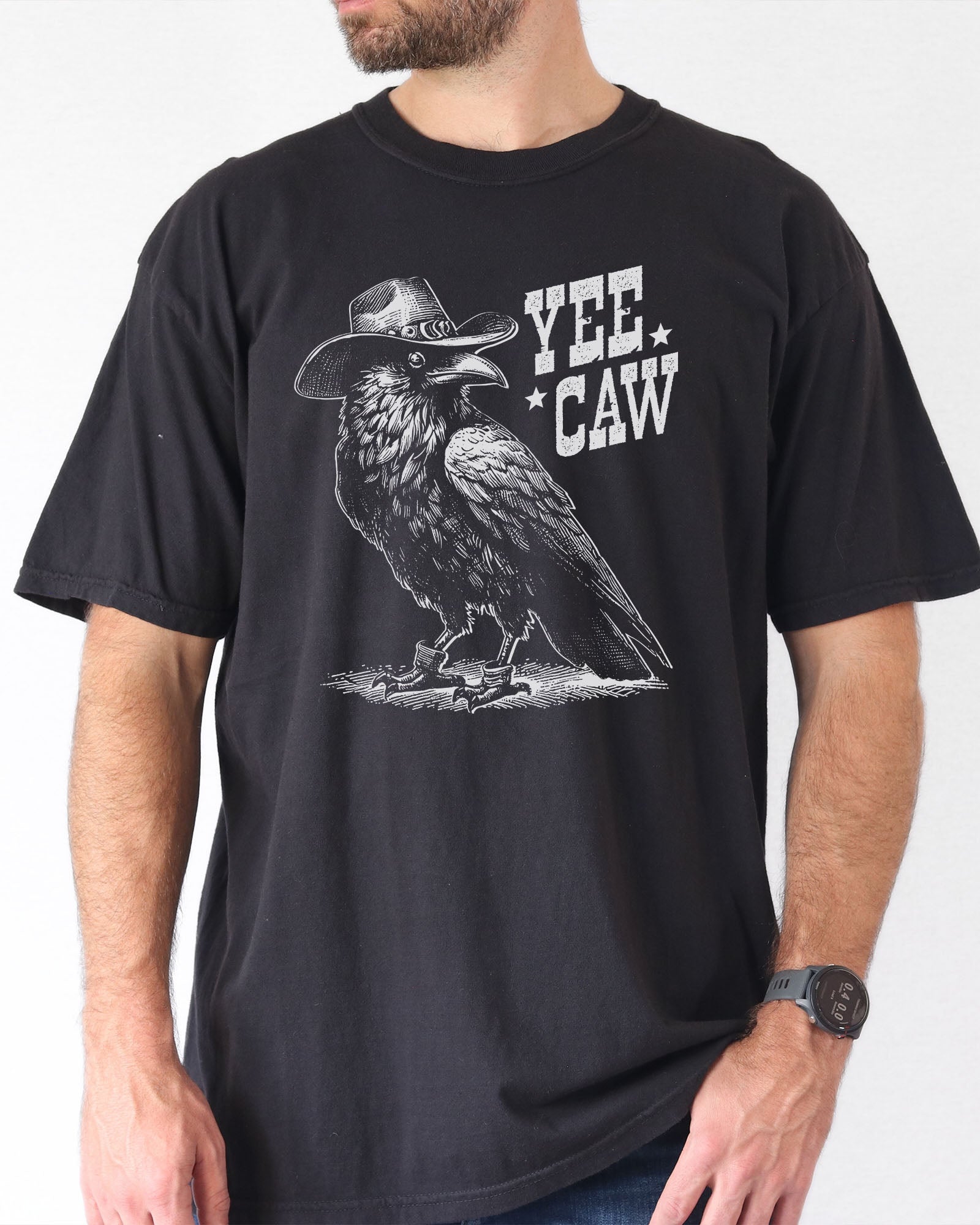 Man wearing black-colored 'Yee Caw' shirt featuring a funny retro cowboy crow graphic.