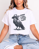 Woman wearing white-colored 'Yee Caw' shirt featuring a funny retro cowboy crow graphic.