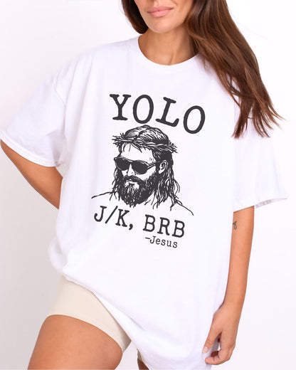 Model wearing white color shirt with 'YOLO J/K BRB Jesus' graphic design