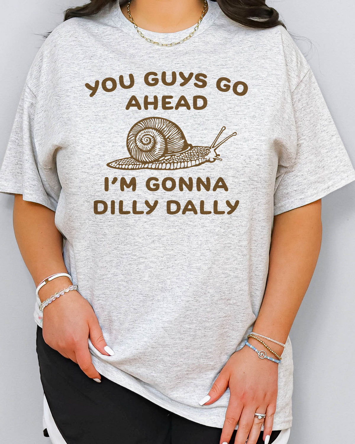 You Guys Go Ahead I'm Gonna Dilly Dally shirt in ash grey color with a retro snale graphic
