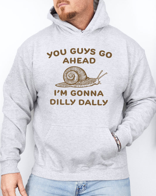 Man wearing an ash gray hoodie with a funny retro-style snail graphic and the quote 'You Guys Go Ahead, I'm Gonna Dilly Dally'.