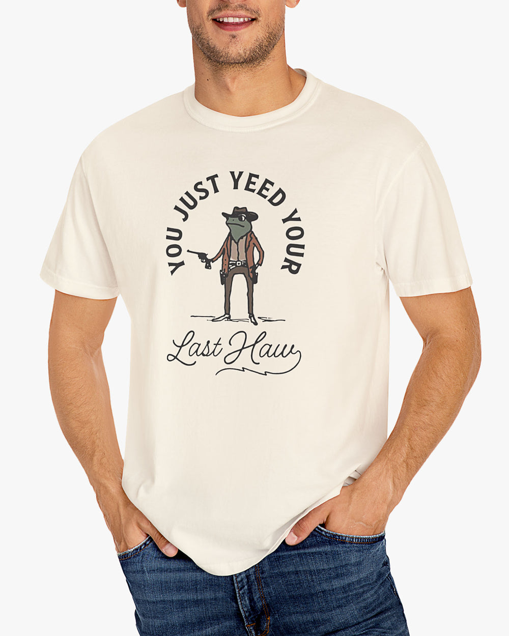 Man wearing natural beige 'You Just Yeed Your Last Haw' shirt with funny retro cowboy frog graphic
