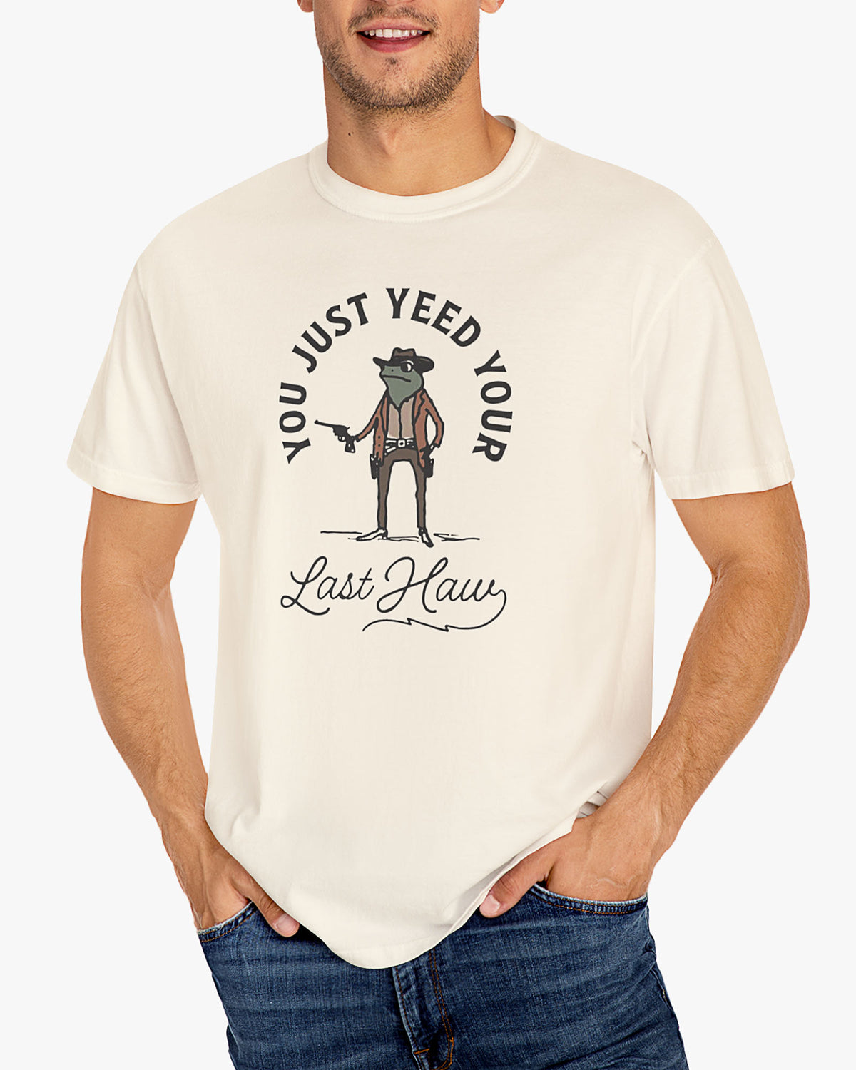 Man wearing natural beige 'You Just Yeed Your Last Haw' shirt with funny retro cowboy frog graphic
