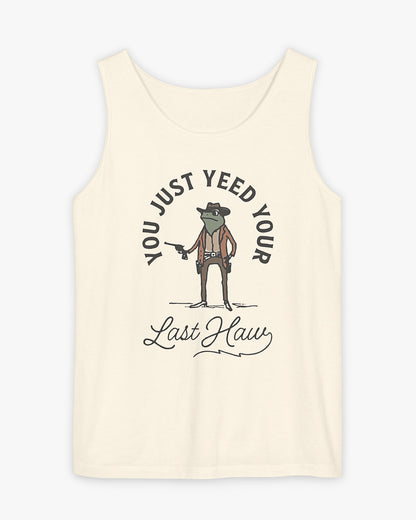 Flat laying natural 'You Just Yeed Your Last Haw' tank top with funny retro cowboy frog graphic