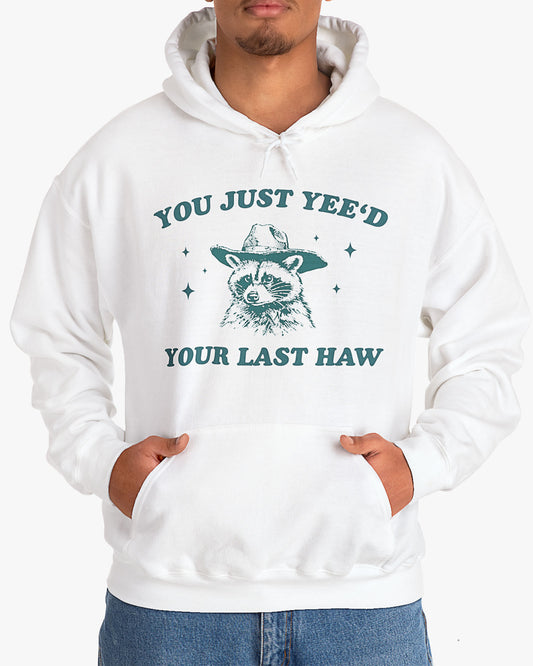 Man wearing white 'You Just Yeed Your Last Haw' hoodie with funny cowboy raccoon graphic