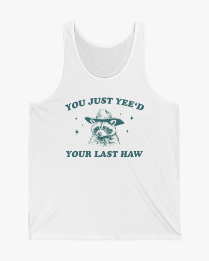 Flat laying white 'You Just Yeed Your Last Haw' tank top with funny retro cowboy raccoon graphic