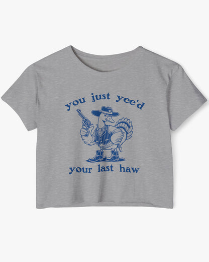 Flat lay of a dark heather 'You Just Yee'd Your Last Haw' crop top featuring a funny retro cowboy goose graphic.