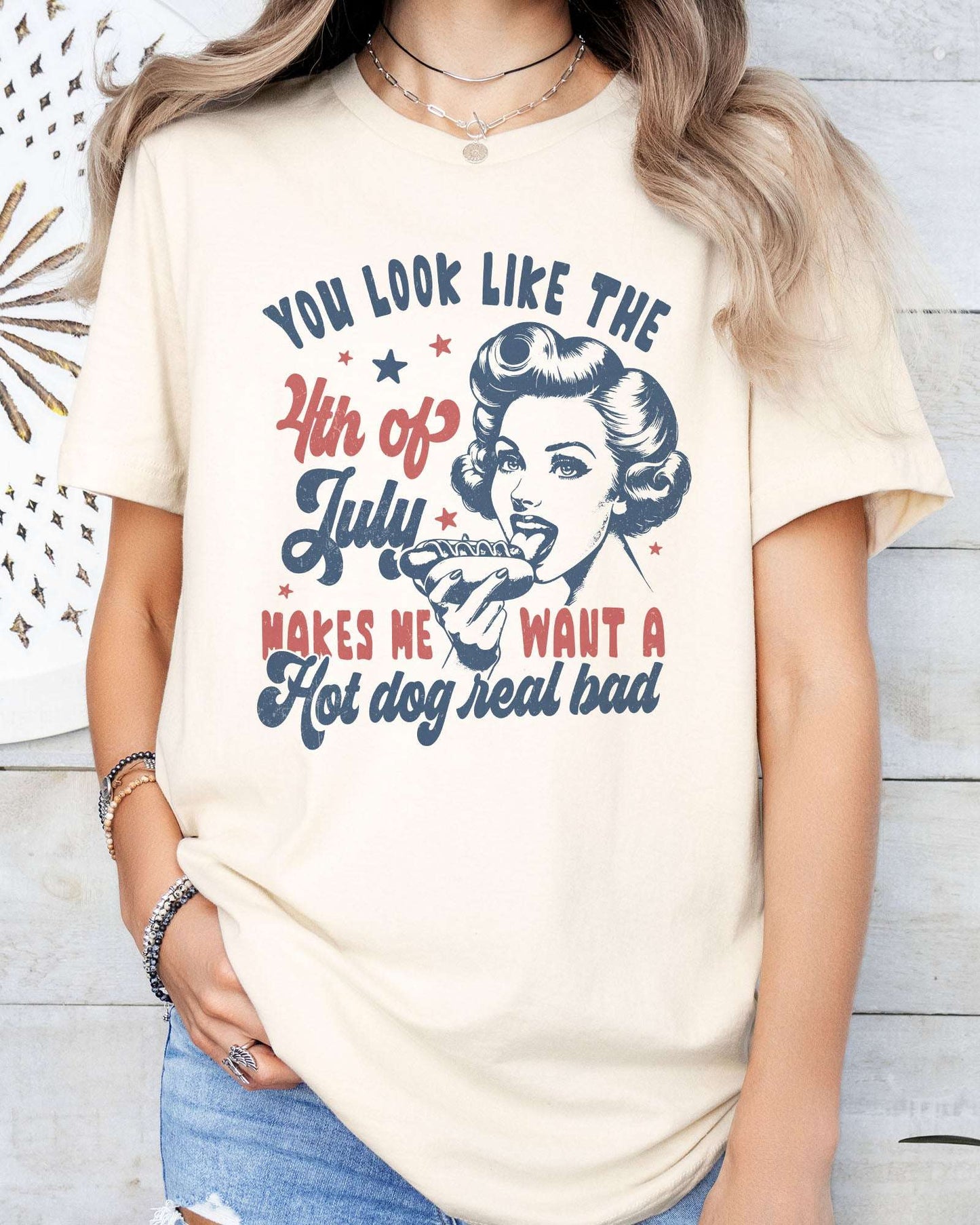 Model wearing natural  color shirt with 'You Look Like The 4th Of July' graphic design
