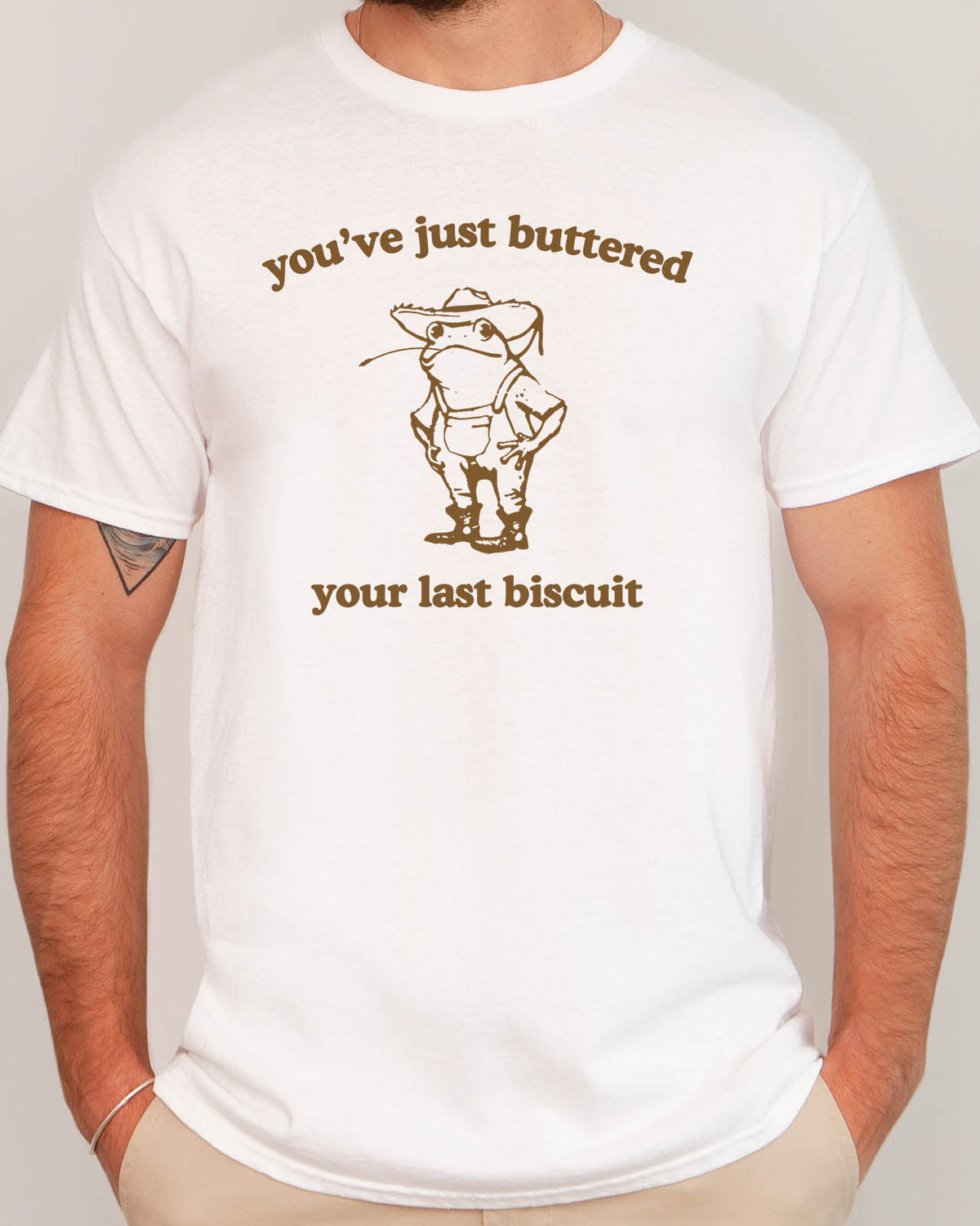 Man wearing funny retro graphic shirt in white color with the quote "You've Just Buttered Your Last Biscuit"