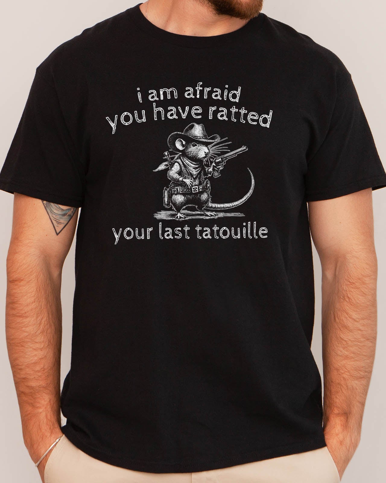 Man wearing "You Have Ratted Your Last Tatouille" Shirt in black color with a retro cowboy rat graphic