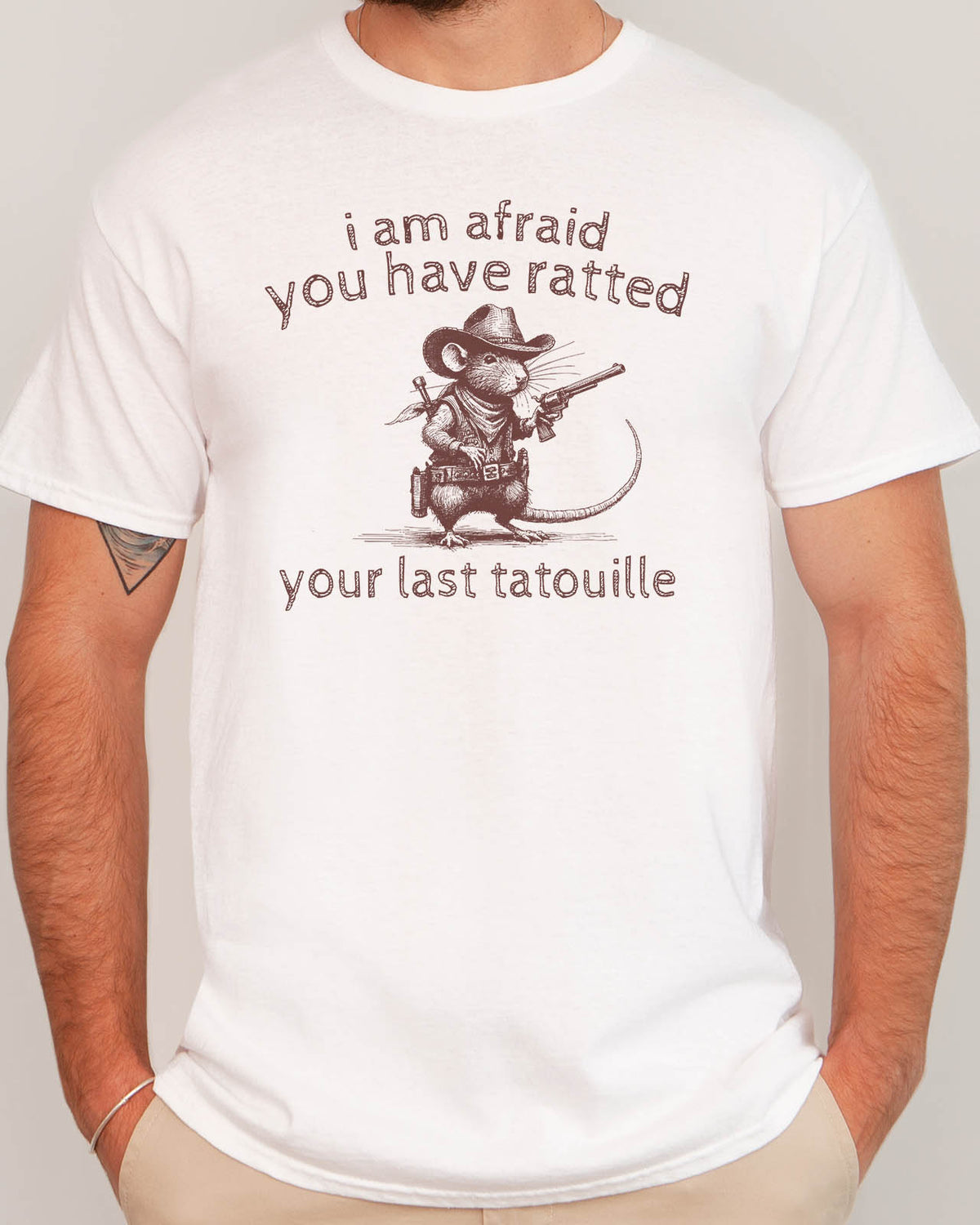 Man wearing "You Have Ratted Your Last Tatouille" Shirt in white color with a retro cowboy rat graphic